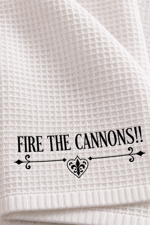 White microfiber pirate bathroom hand towel printed with "FIRE THE CANNONS!!" in black lettering over a vintage scroll flourish, 16 x 25 inches, alternate view