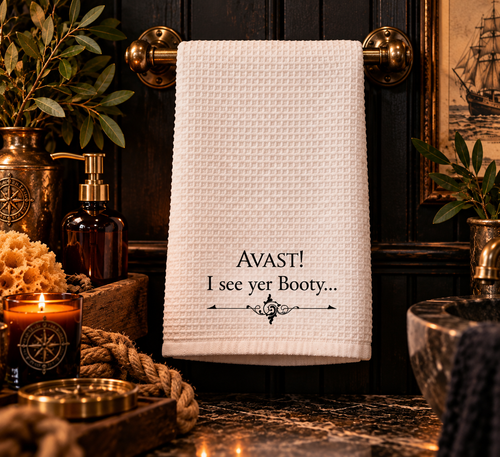 White microfiber pirate bathroom hand towel printed with "AVAST! I see yer Booty..." in black lettering over a vintage scroll flourish, 16 x 25 inches