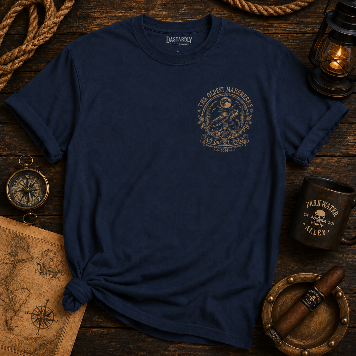The Oldest Mariners sea turtle t-shirt, front: a small engraved seal on the left chest of a navy tee