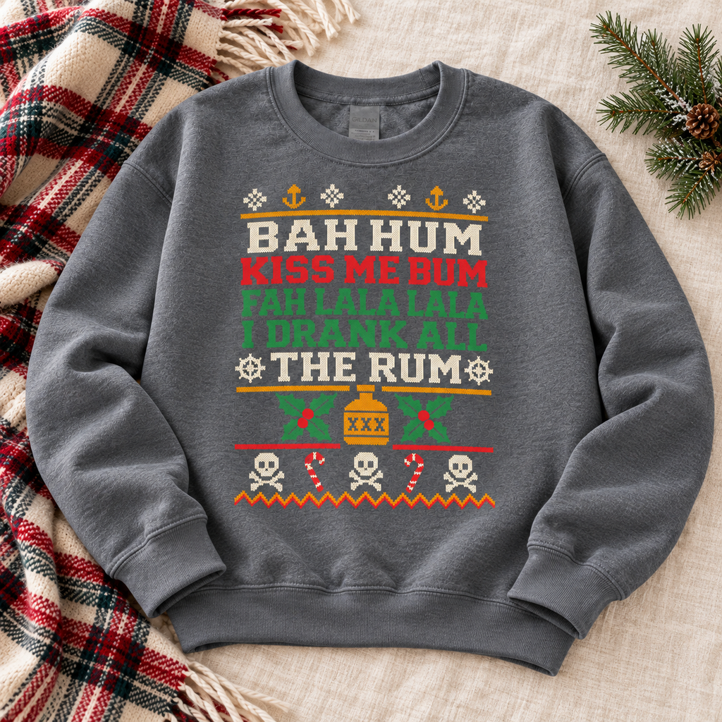 Dark Heather Bah Hum Kiss Me Bum sweatshirt flat lay on a plaid blanket with pine branches