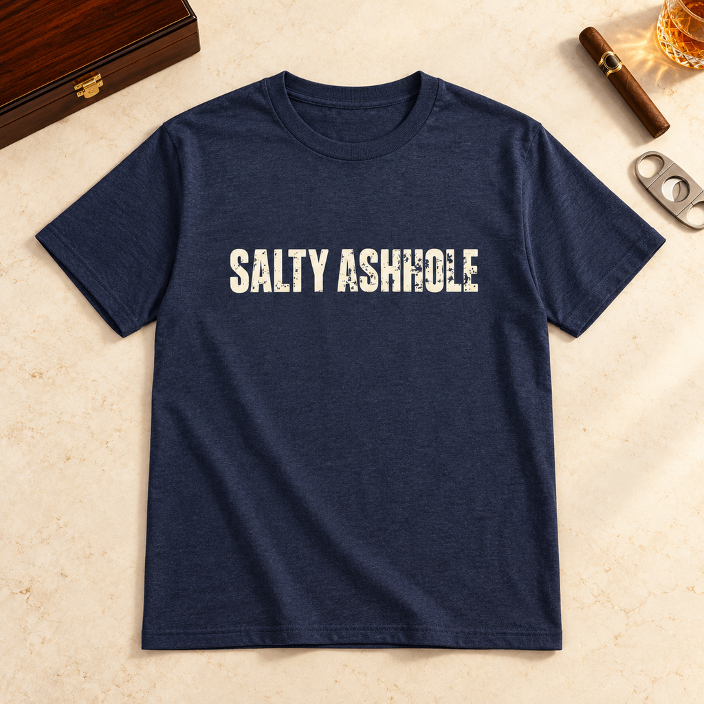 Navy Salty Ashhole tee laid flat beside a cigar cutter and a glass of whiskey