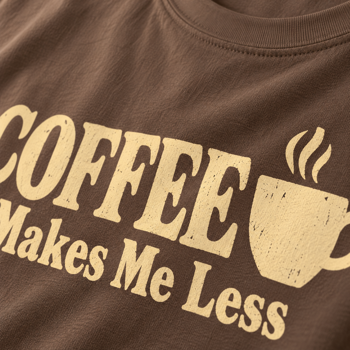 Close-up of the weathered cream COFFEE lettering and steaming cup print on an Espresso brown tee