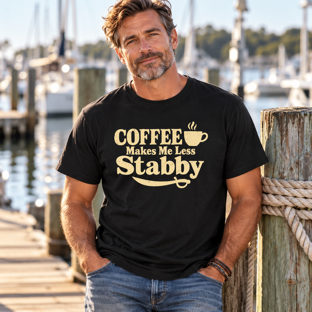 Man standing on a dock in a black Coffee Makes Me Less Stabby t-shirt with the pirate cutlass under Stabby