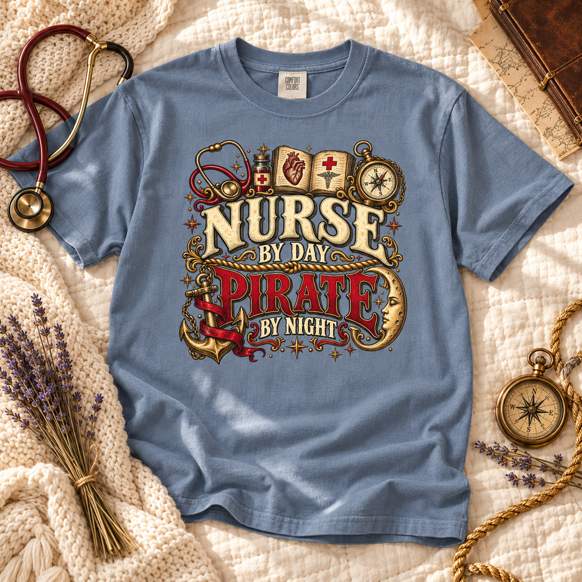 Blue Jean Nurse by Day Pirate by Night tee laid flat with a stethoscope, lavender and a brass compass