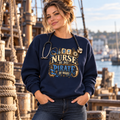 Nurse with a stethoscope on a ship dock wearing a navy Nurse by Day Pirate by Night sweatshirt with ceil blue PIRATE