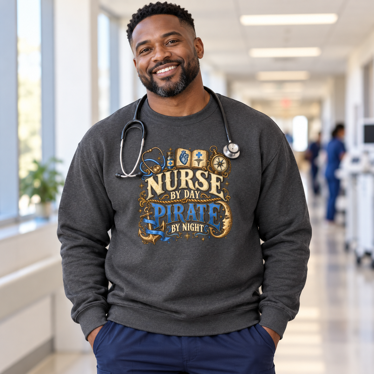 Male nurse in a hospital hallway wearing a dark heather Nurse by Day Pirate by Night sweatshirt in ceil blue and gold